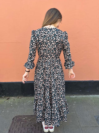 Eco-friendly floral dress with vintage-inspired print and feminine ruffle cuffs, ideal for a slow fashion wardrobe.