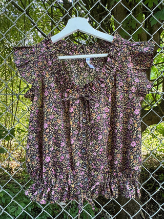 floral blouse on chain link fence