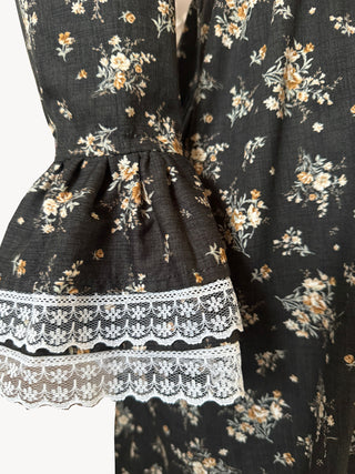 Black floral dress with lace trim on a plain background