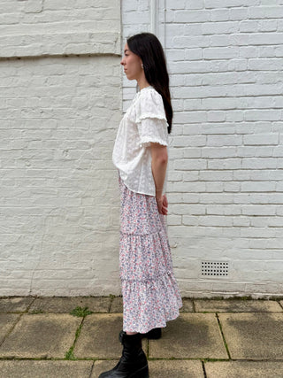 Side view of sustainable three-tier cotton skirt with gathered ruffle detail and elastic waistband.