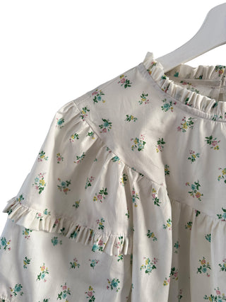 The Lucy Ruffle Top in Liberty x Bridgerton print, featuring a ruffled yoke, fluttering sleeves, and a soft floral pattern in a sustainable cotton fabric.