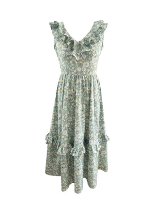A sleeveless V-neck dress with a ruffled neckline and tiered skirt, featuring a light sage green and beige floral pattern, shown against a plain white background.