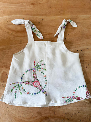 White apron with floral embroidery on a wooden surface