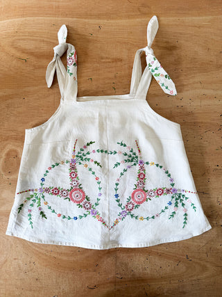 White apron with floral embroidery on a wooden surface
