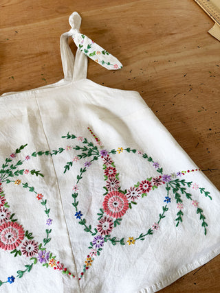 Embroidered dress with floral patterns on a wooden surface