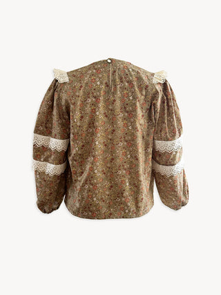 Floral blouse with lace details on a white background