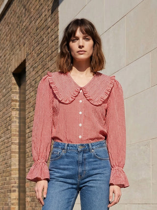 model wearing red gingham blouse