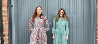 women wearing dresses against painted door