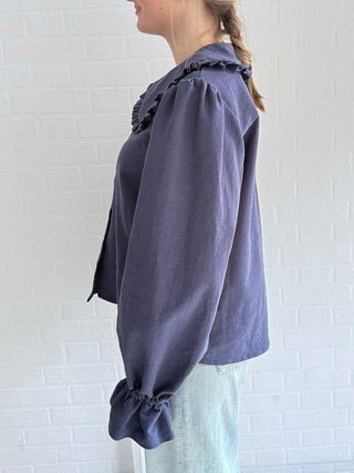 Versatile sustainable wardrobe – model pairing navy blouse with tailored trousers