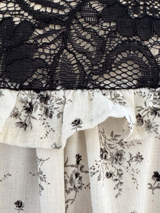 Close-up of black lace fabric with floral patterns on a white background