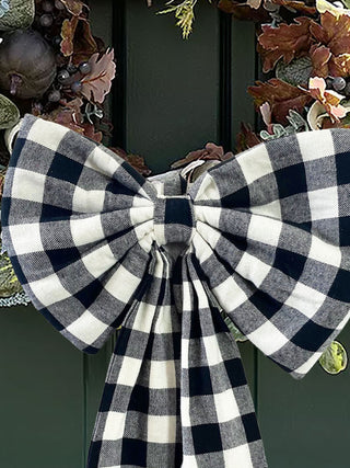 Black and white checkered bow on a decorative wreath against a dark background