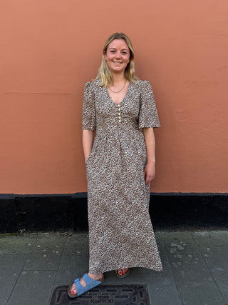 Front view of The Rebecca Dress with leopard print, vintage-style buttons, and puff sleeves, perfect for a stylish and sustainable wardrobe.