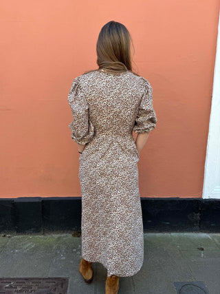Back view of The Ottilie Dress showing flowing A-line shape and gathered sleeves in ethical leopard print fabric.