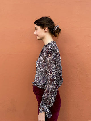 women wearing paisley boho blouse by wall
