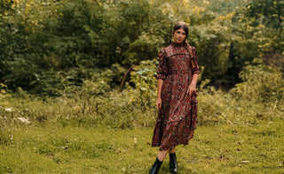 Woman in a patterned dress standing in a forest