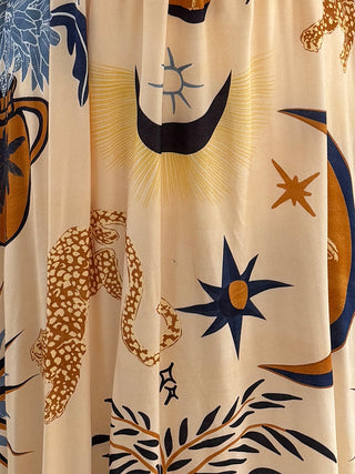 The Seraphina Celestial V-Neck Dress with starry and botanical patterns, featuring a flowing midi length and relaxed fit for comfortable wear.