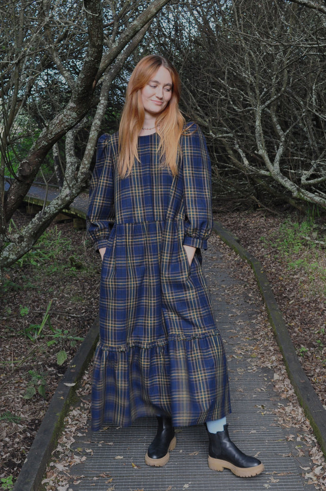 woman on walk wearing check dress with pockets