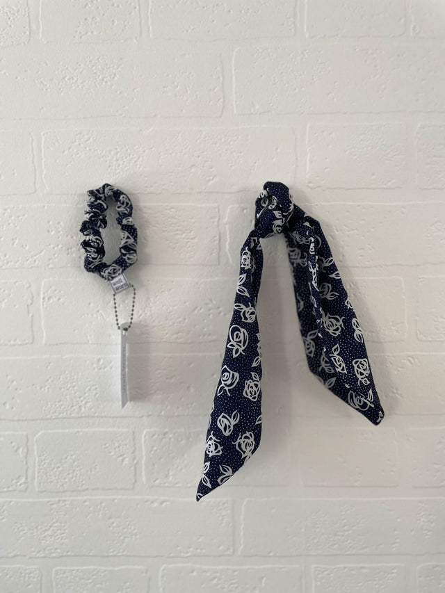 navy and white printed hair tie on wall 