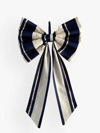 Navy and white striped bow with long ribbons on a white background