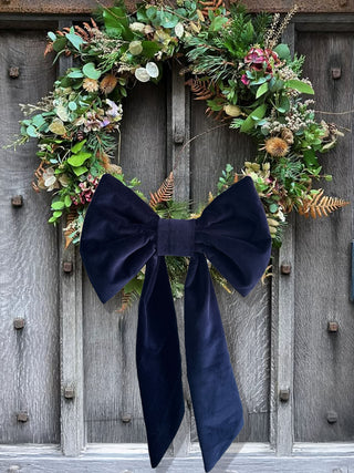 velvet bow on wreath on wooden door
