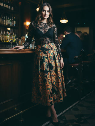 Woman in a stylish outfit standing in a bar setting