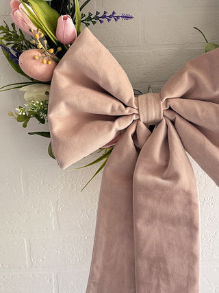 Close-up of fabric bows on a spring Easter wreath, featuring pastel colors and eco-friendly design for a sustainable holiday decoration