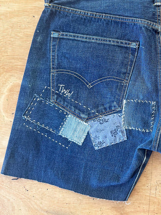 Close-up of a blue denim pocket with 'Twill' text on a wooden surface
