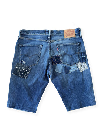 Blue denim shorts with patchwork design on a white background