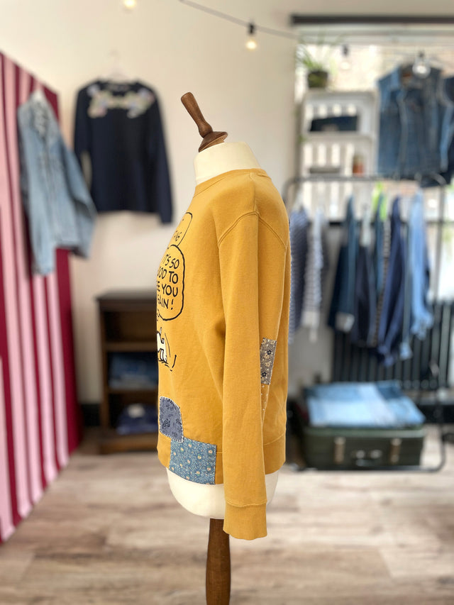 The Well Worn yellow snoopy sweatshirt on mannequin side