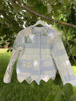 vintage quilted jacket on hanger in tree