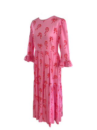 Sustainable pink bow dress on a mannequin, designed with a beautiful bow print and classic fit