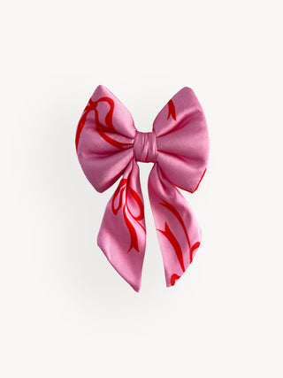 Pink bow with red patterns on a white background