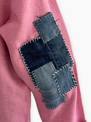 Pink sweatshirt with a denim patch on a white background