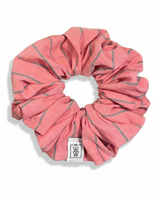 Pink and gray striped shower cap with a visible brand logo on a white wooden background