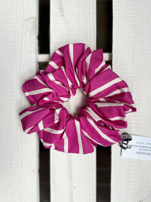 The Well Worn pink stripe scrunchie on wooden table