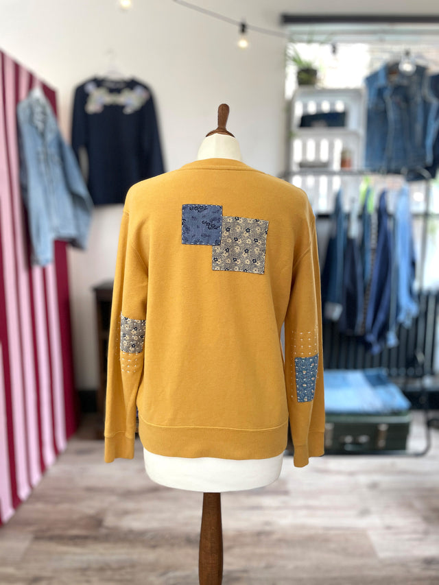 The Well Worn yellow snoopy sweatshirt on mannequin back