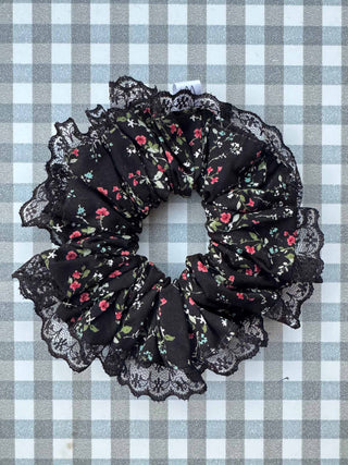 Black floral scrunchie with lace details on a checkered background
