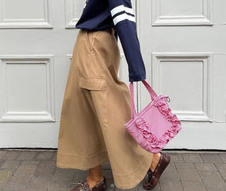woman on street with red gingham bag
