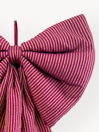Close-up of a pink and white striped bow with a white background
