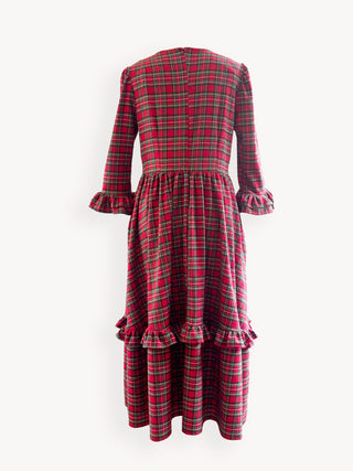 Red and green plaid dress with ruffled details on a white background
