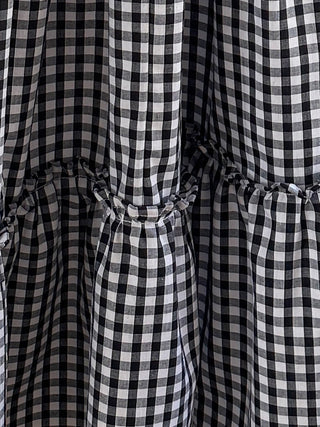 The Romana Gingham Tiered Maxi Skirt with ruffled details, side pockets, and elastic waistband in classic black & white gingham.