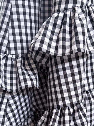 Close-up of a black and white checkered fabric with ruffled layers.