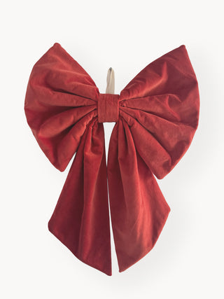 Red velvet bow hair clip on a white background