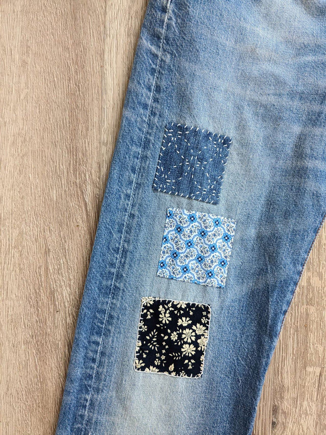 The Well Worn patched upcycled levi jeans on floor