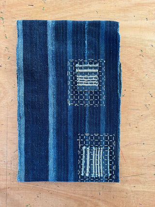 Blue textured fabric with geometric patterns on a wooden surface
