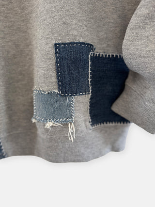 Gray sweater with denim patch on a white background