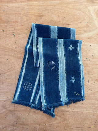 Two blue scarves with patterns on a wooden surface