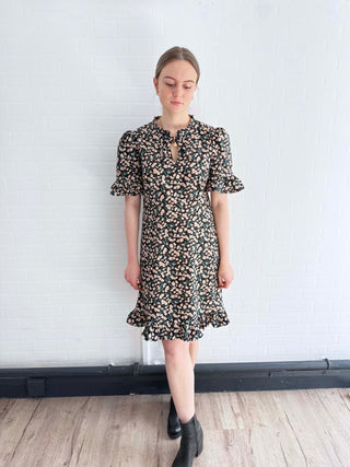 Front view of sustainable floral mini dress with ruffle hem, crafted in the UK.