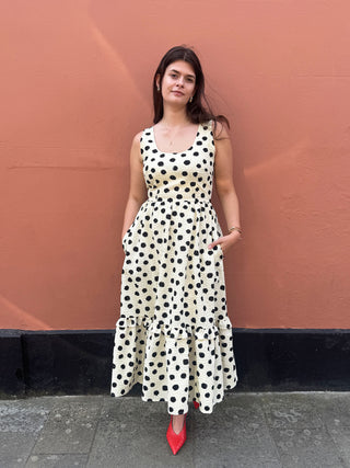 woman wearing spot dress stood by wall