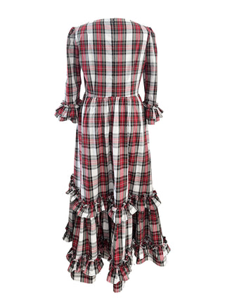 A long-sleeved plaid dress shown from the back, featuring a red, black, and white tartan pattern with ruffled details at the waist and hem.